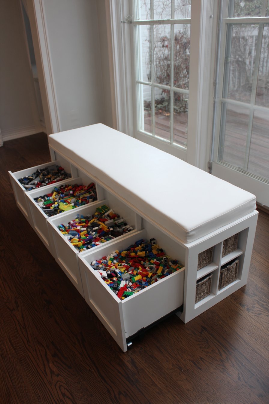 White built-in mudroom bench with lift-up seat, pull-out Lego bins on casters and fabric basket cubbies