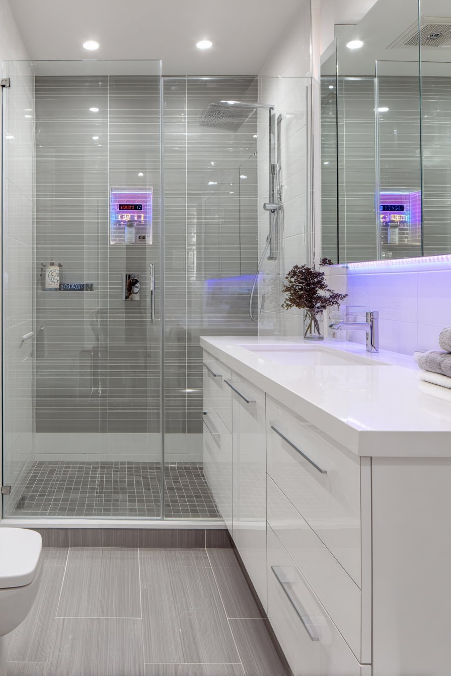 Frameless glass shower with digital control panel, smart mirror display and high-gloss white floating vanity
