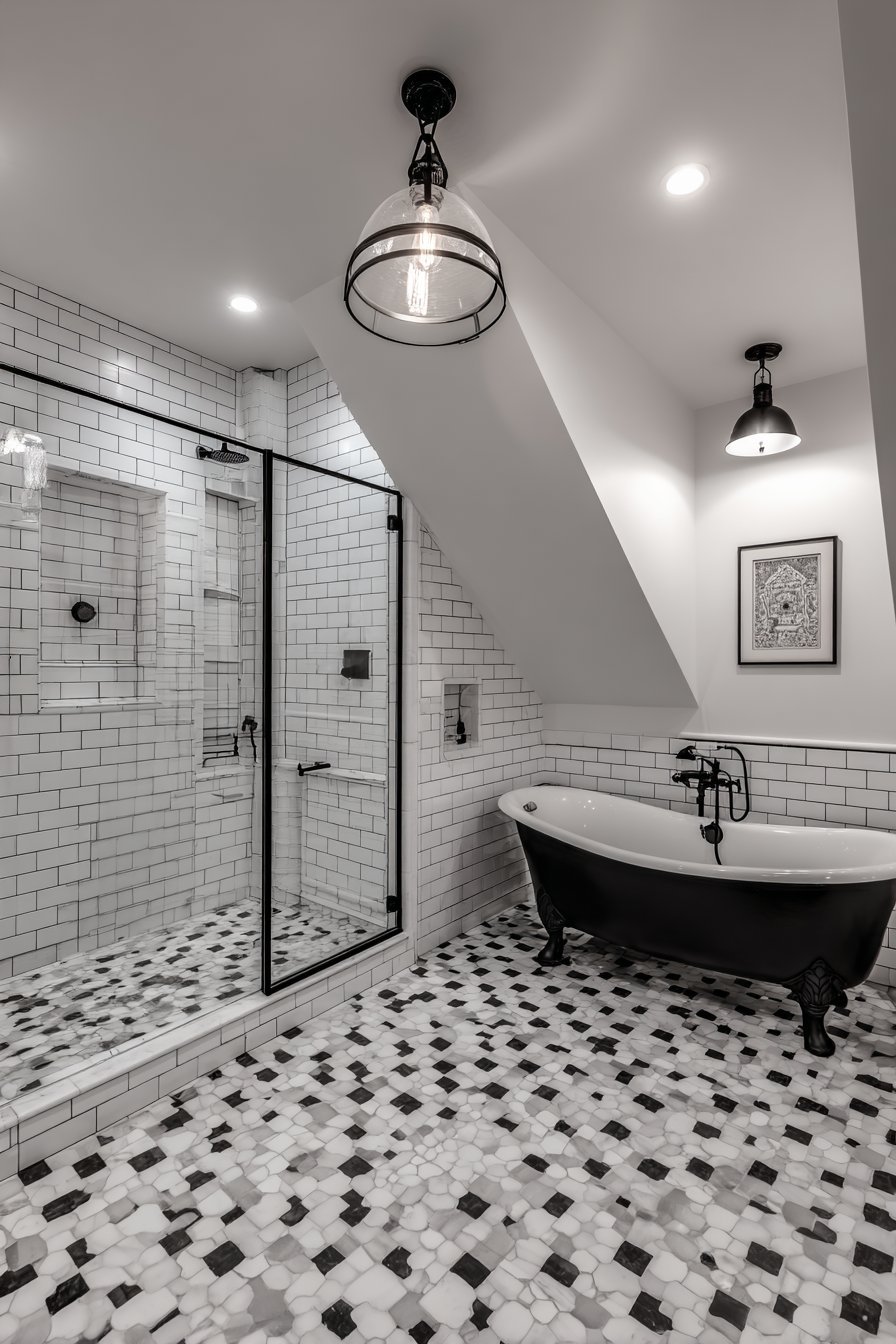 Black and white master bathroom with hexagonal marble floor, black clawfoot tub and black-framed shower