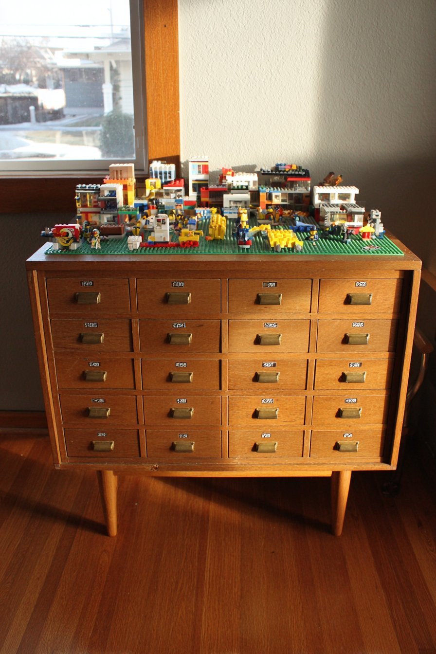 Honey oak 30-drawer cabinet with brass label holders on a table with a green baseplate and mini builds on top