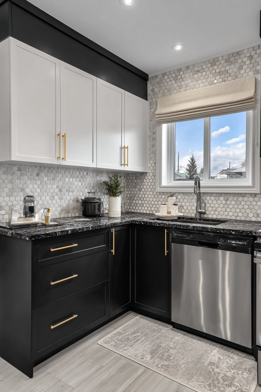 Black lower cabinets, white uppers, hexagonal tile backsplash and brass hardware in a compact kitchen