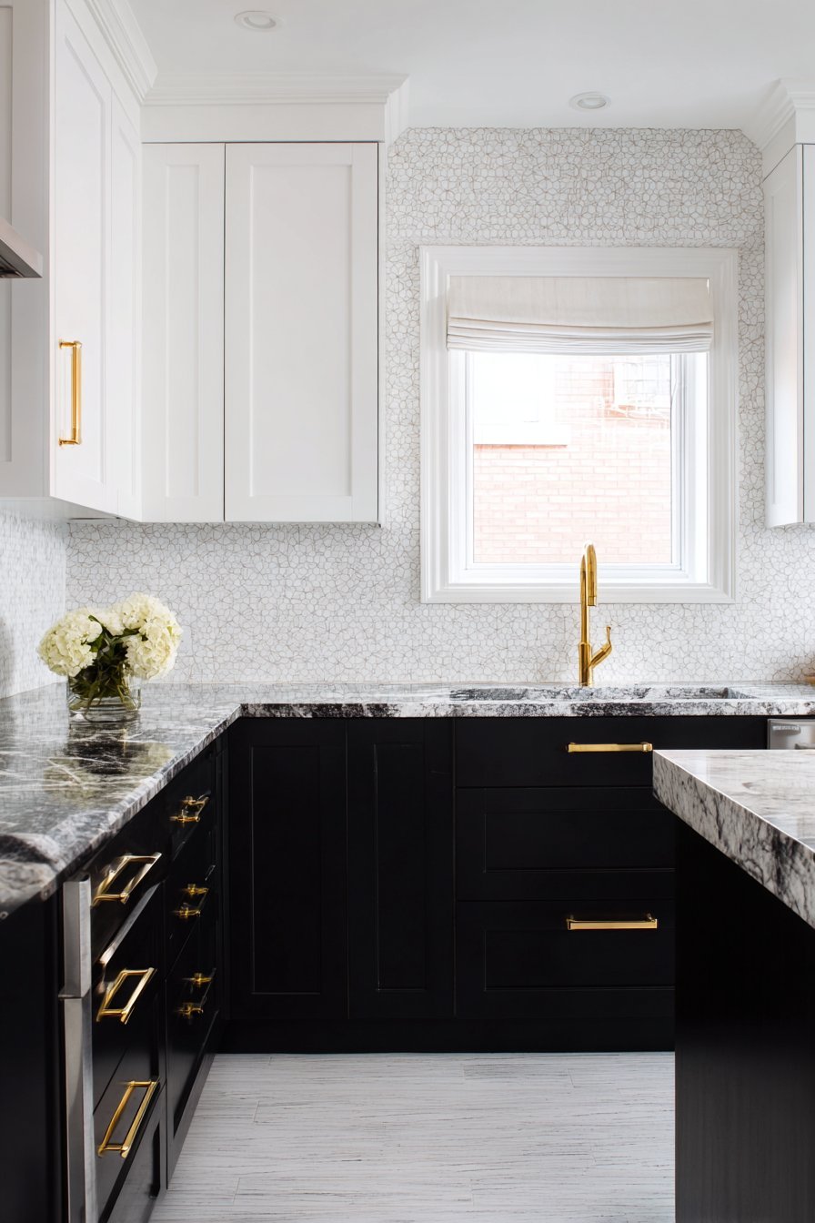 Black lower cabinets, white uppers, hexagonal tile backsplash and brass hardware in a compact kitchen