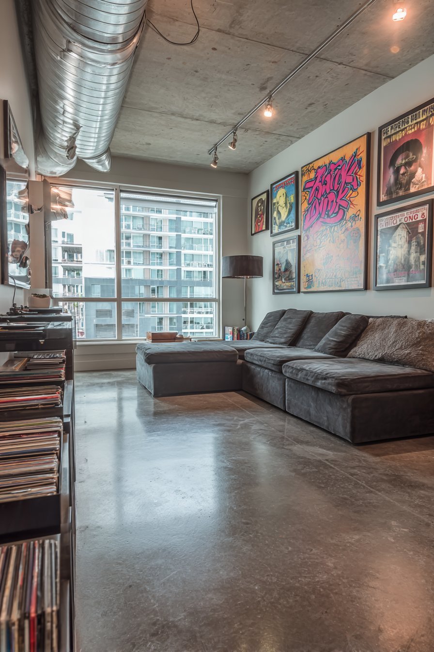 Urban living room with large street art canvas, concert posters and charcoal modular sofa on concrete floors
