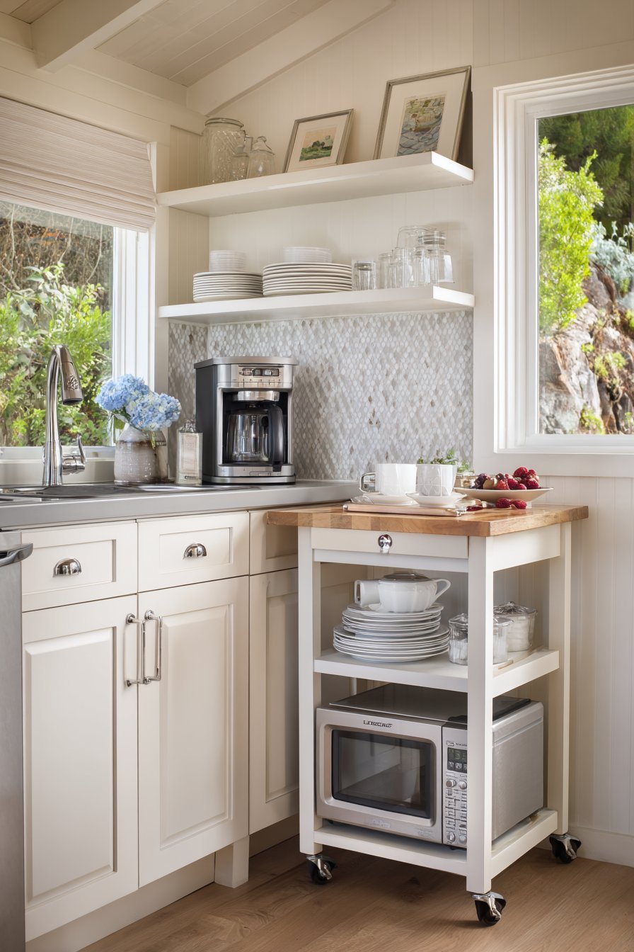 Two-tier wood kitchen cart beside white shaker cabinets and a subway tile backsplash