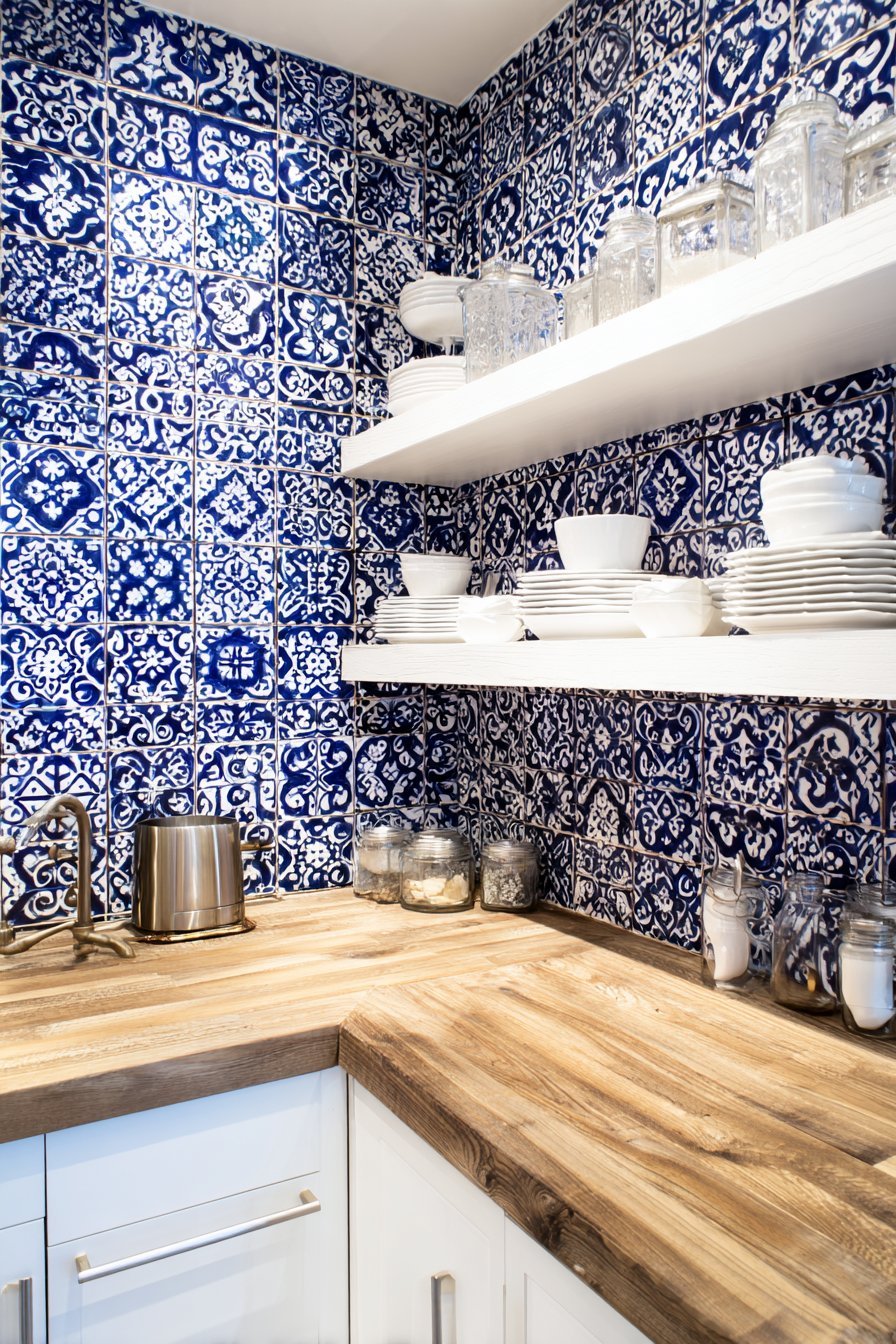 Blue and white Moroccan tile backsplash with white flat-panel cabinets and butcher block counters