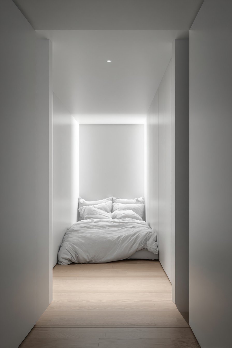 White flush bedroom door with recessed handle and concealed hinges blending into white walls
