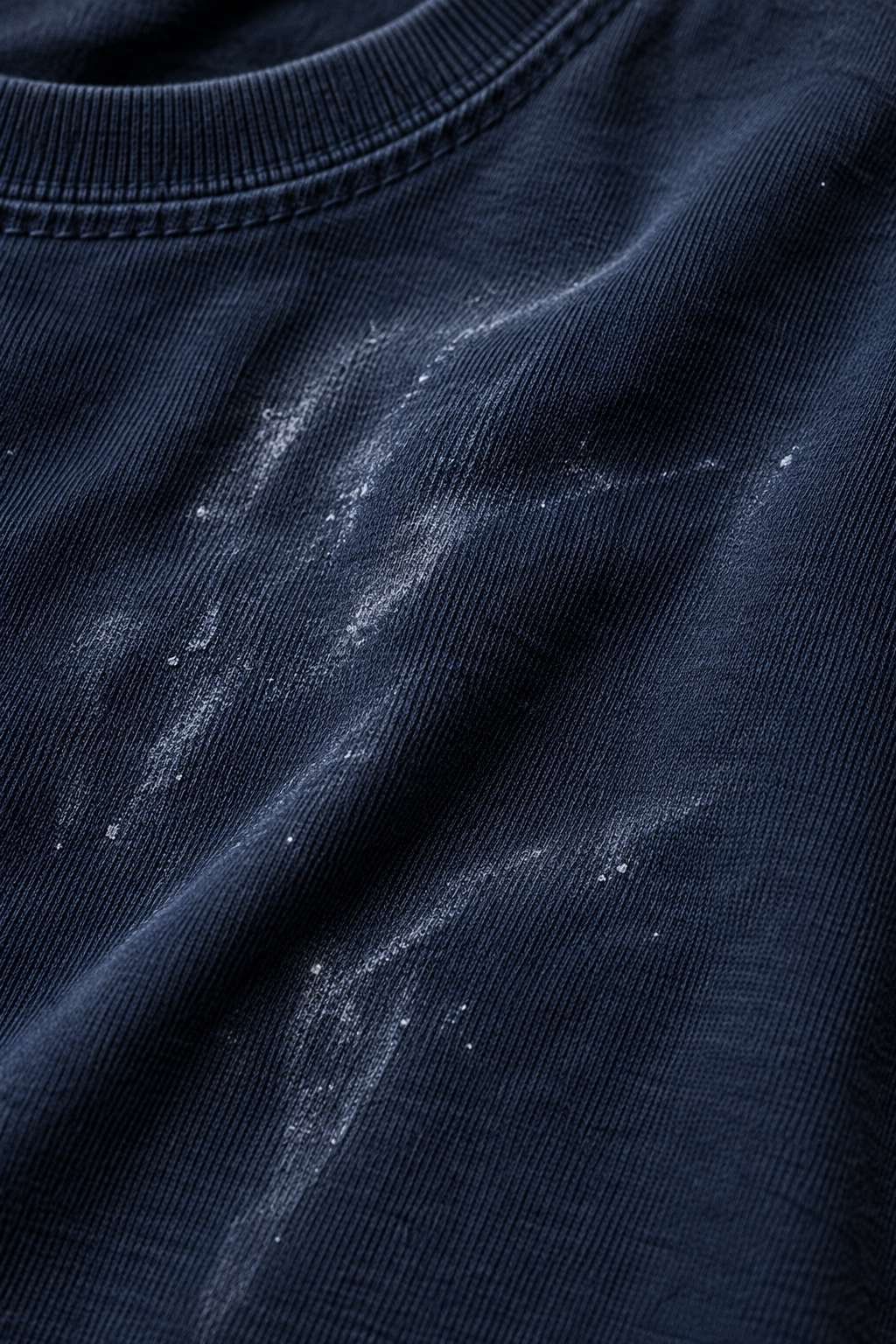 White detergent residue marks on dark fabric